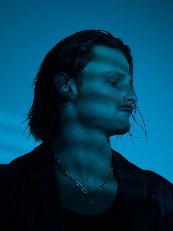 Audent profile portrait looking away in blue light, press photo